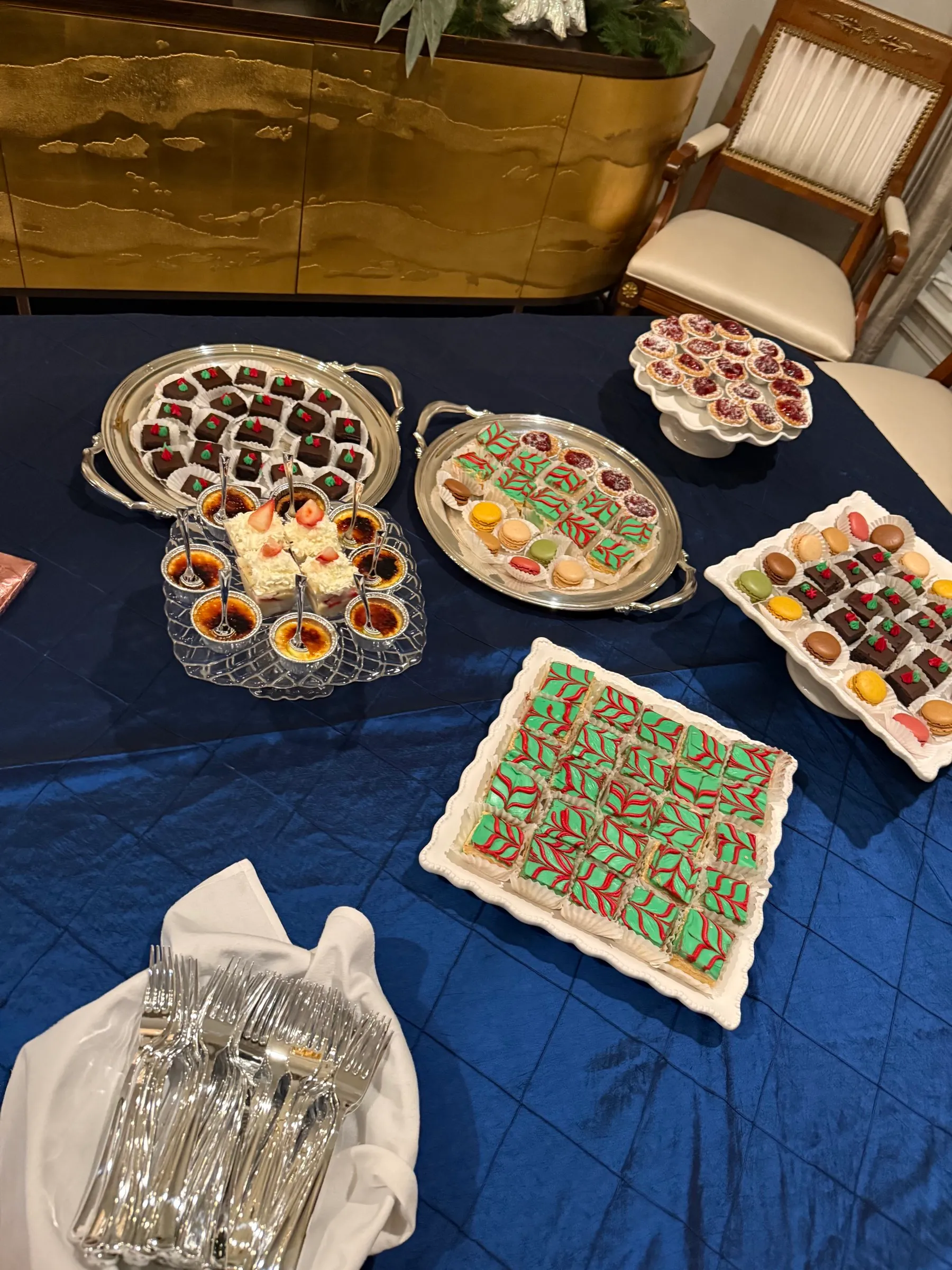 Elegant holiday dessert spread with Christmas macarons, crème brûlée and petits fours