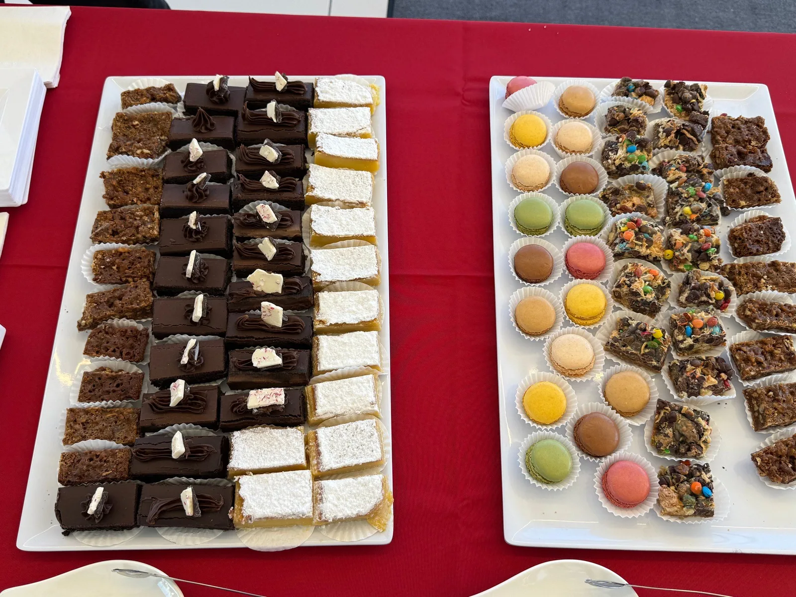 Assorted dessert platters with chocolate petit fours, lemon bars, and colorful macarons