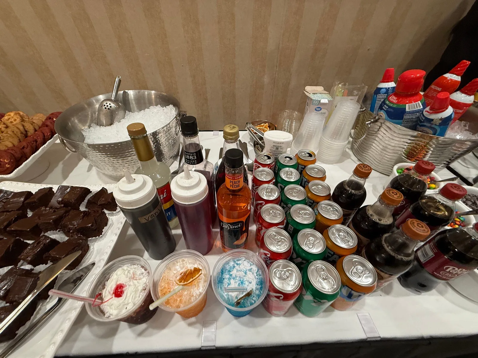 Snowball station with shaved ice, flavored syrups, toppings, and soft drinks