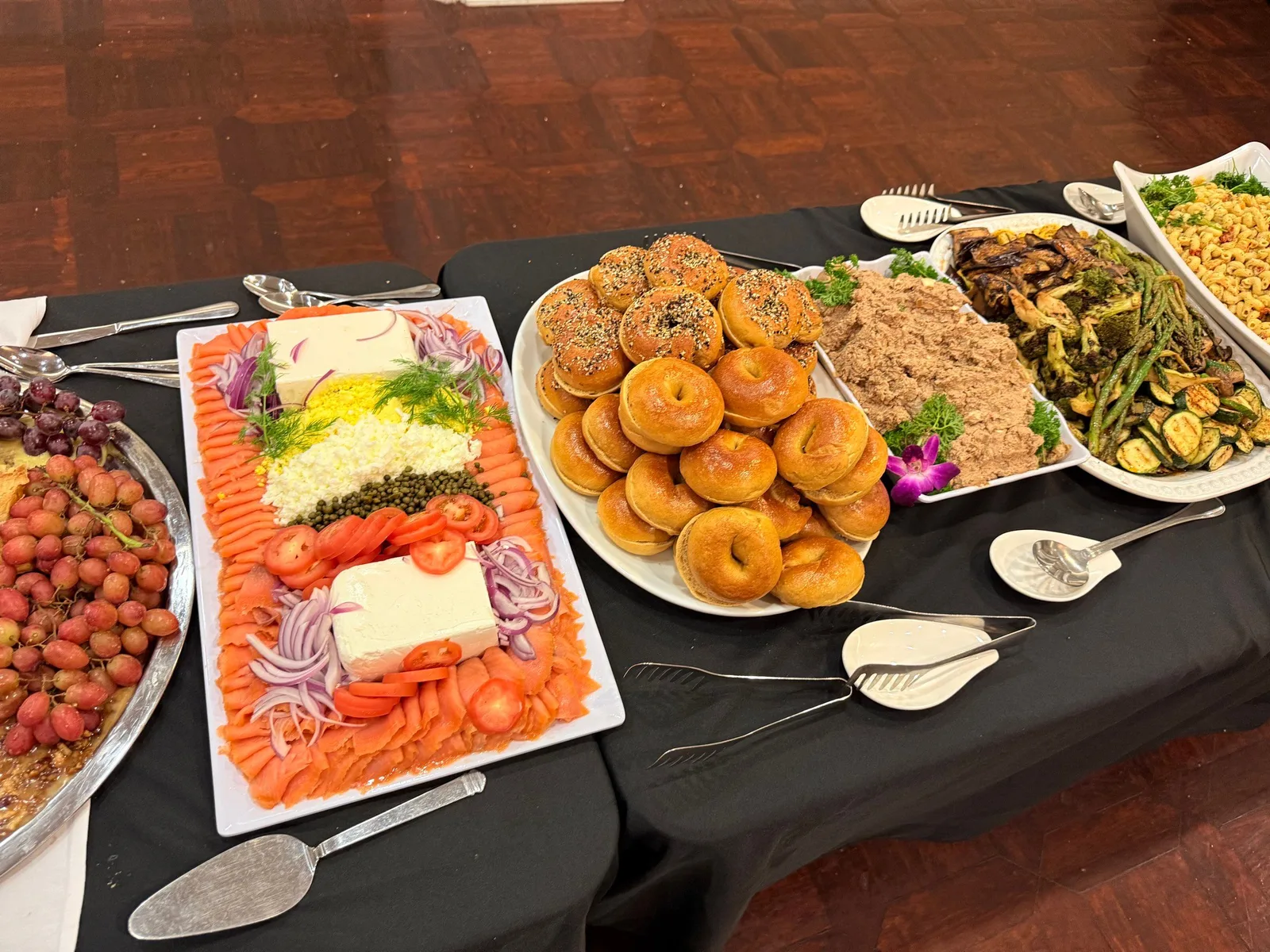 Brunch buffet spread with smoked salmon platter, bagels, tuna salad, and roasted vegetables